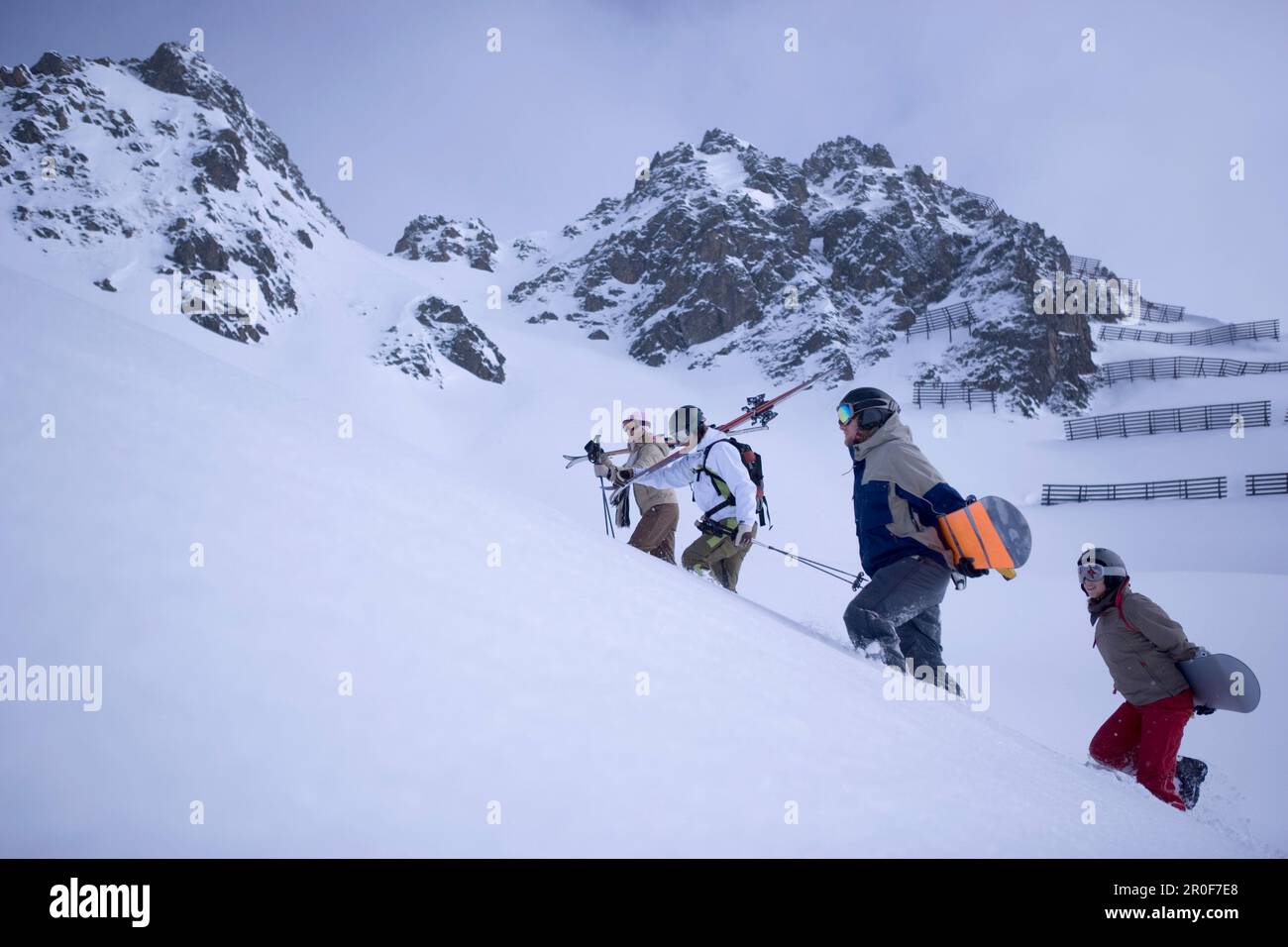 Four young people people carring snowboards or skis, Kuehtai, Tyrol, Austria Stock Photo