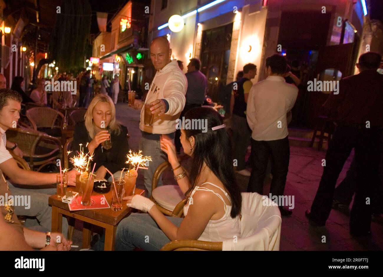 Waiter serving drinks in an open-air bar at night, Kos-Town, Kos, Greece Stock Photo