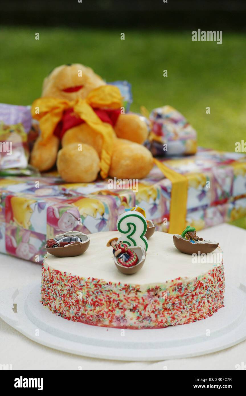 Birthday cake and presents on table Stock Photo