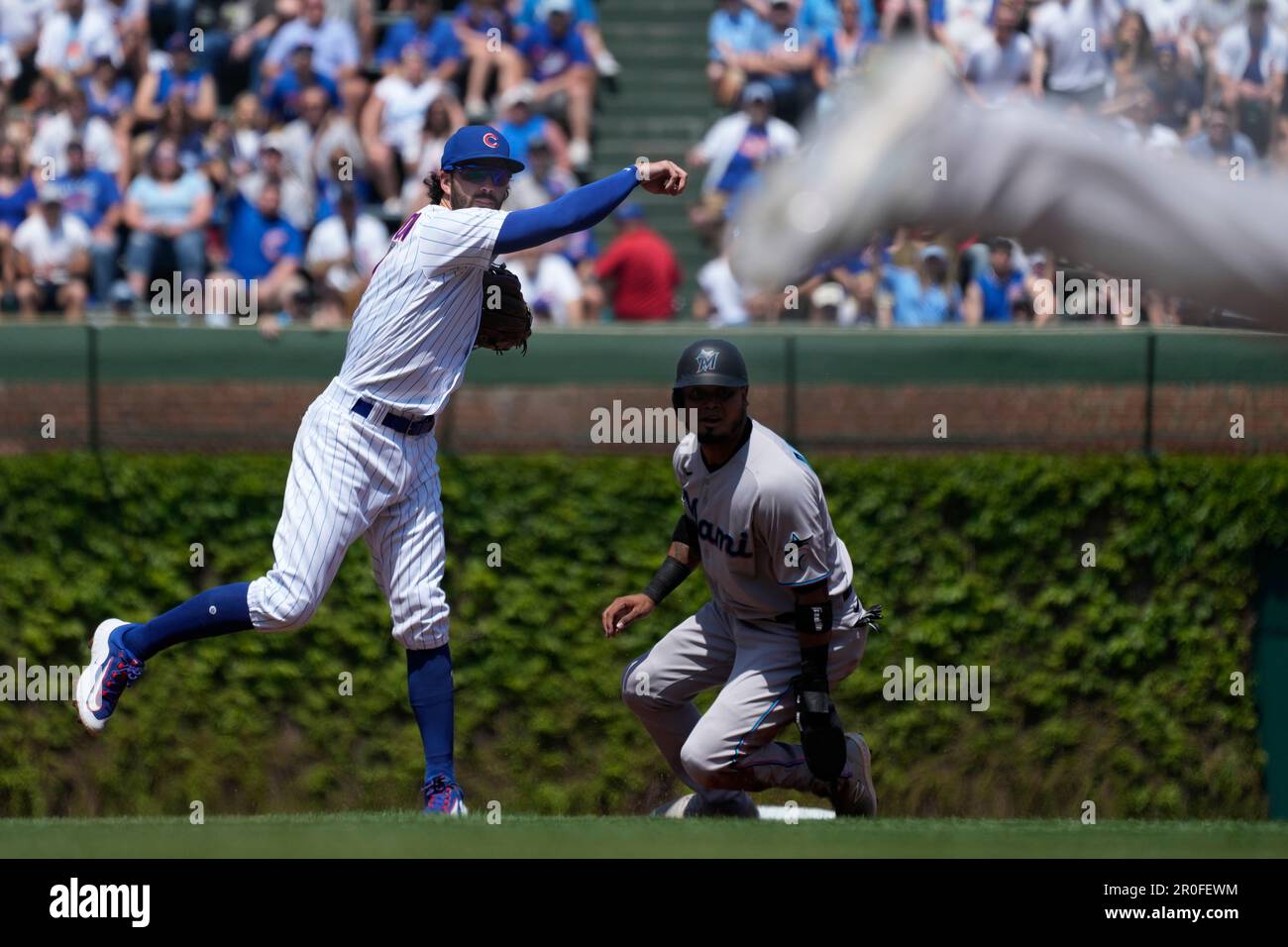 Chicago Cubs shortstop Dansby Swanson, left, throws out Miami Marlins