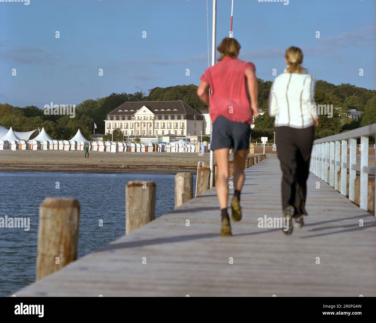 Joggers on the jetty in the morning, beach in front of the Spa Hotel Arosa, Travemuende, Schleswig-Holstein, Germany Stock Photo