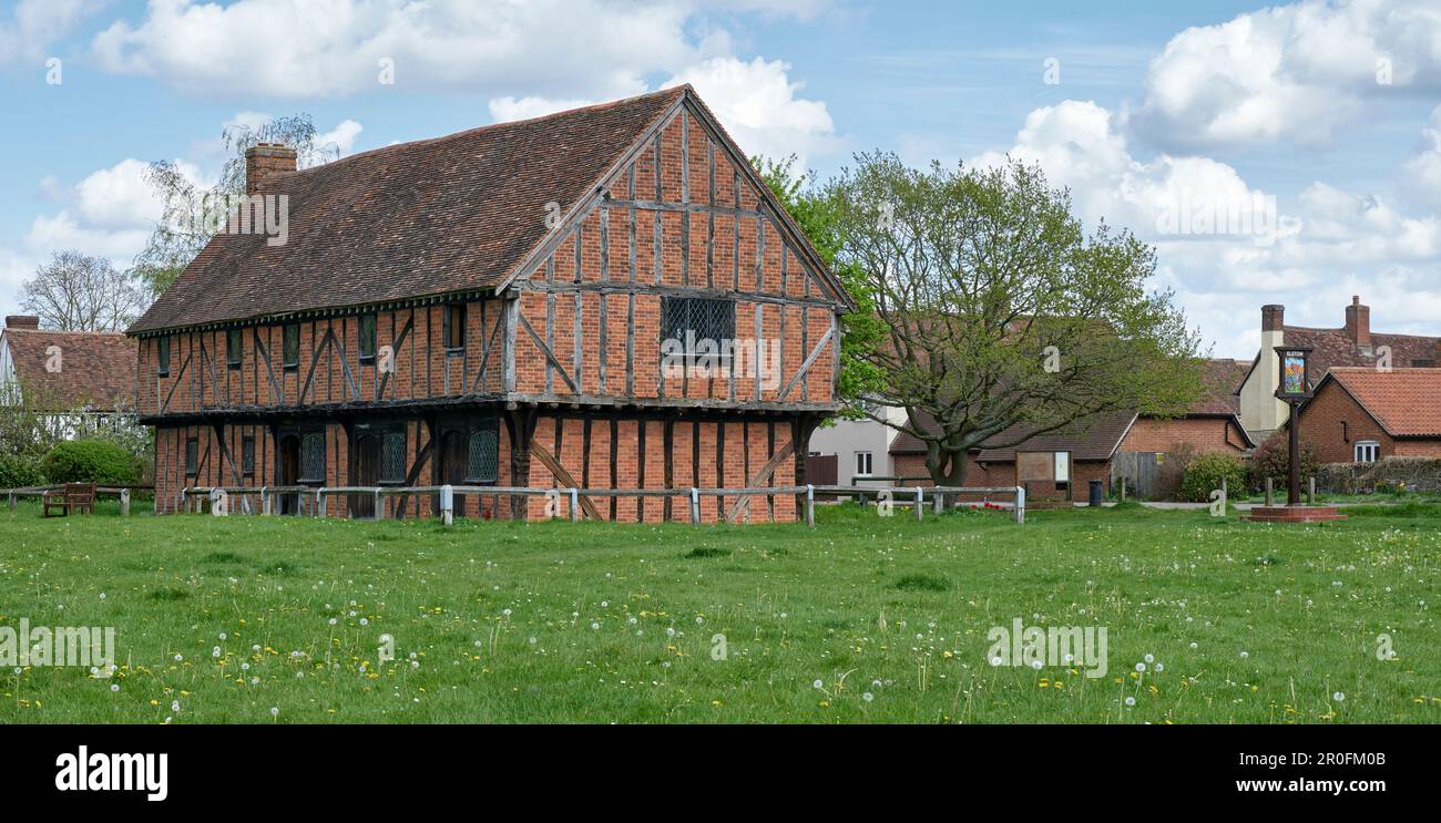 Half-timbered with brick infill Moot Hall on The Green, Elstow village, with village sign on right Stock Photo