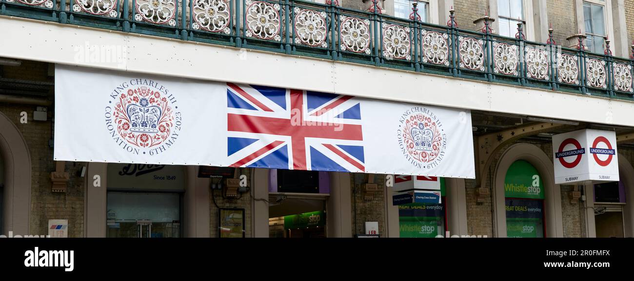 Banner hanging from canopy outside front of Charing Cross station, London, for the coronation of King Charles III and Queen Camilla Stock Photo