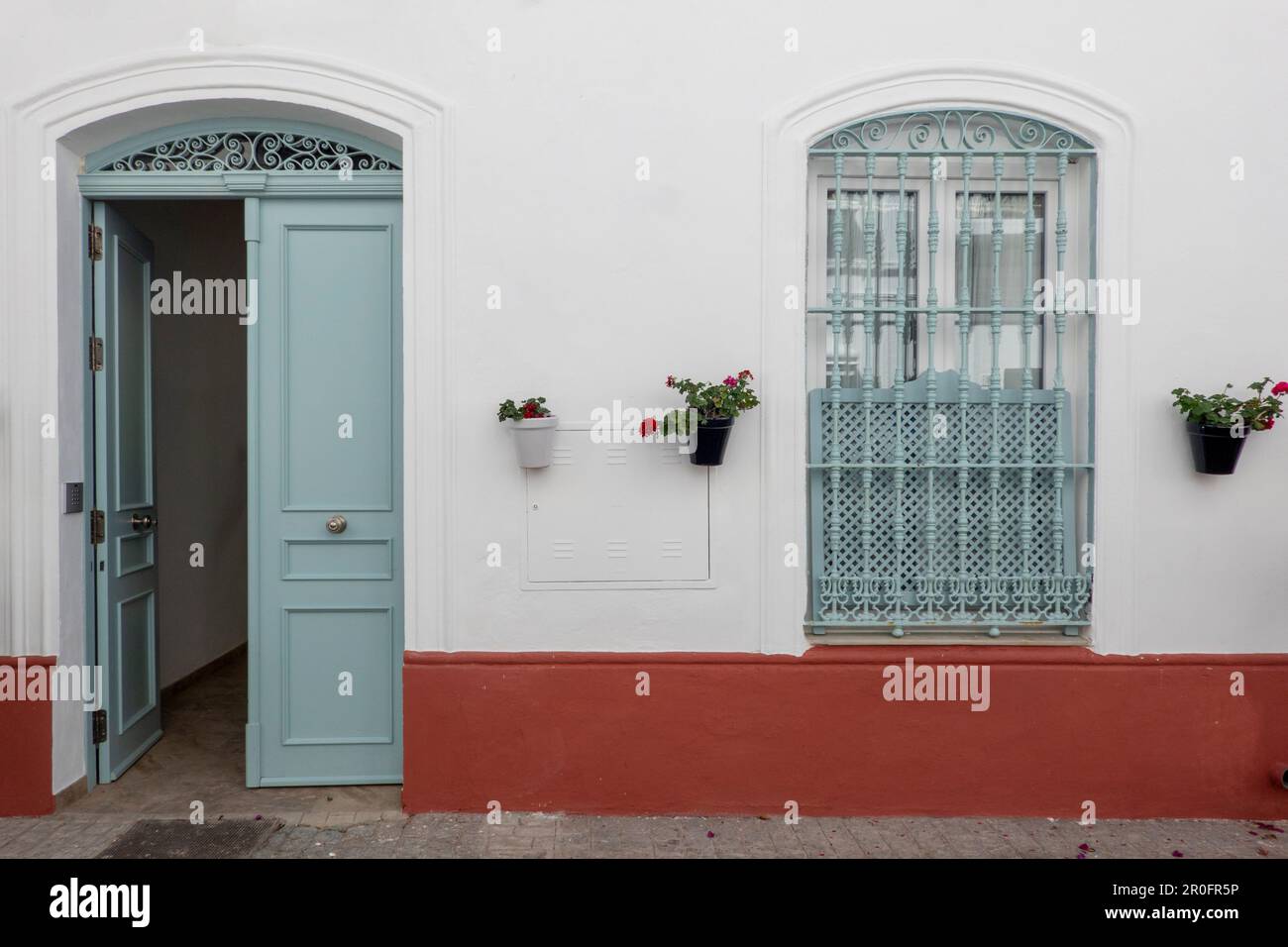 Vintage facade of a house with door and window with bars decorated with ...