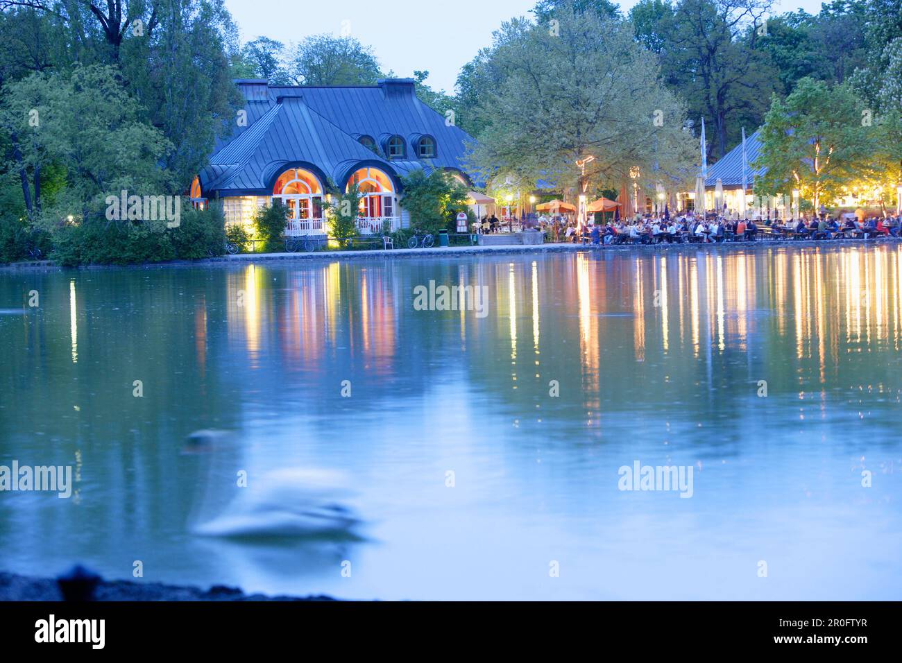 People enjoying themselves at beer garden Seehaus at lake Kleinhesseloher See, English Garden, Munich, Bavaria, Germany Stock Photo