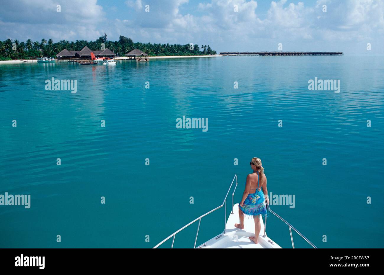 Woman on Bow in front of Island, Maldives, Indian Ocean, Meemu Atoll Stock Photo