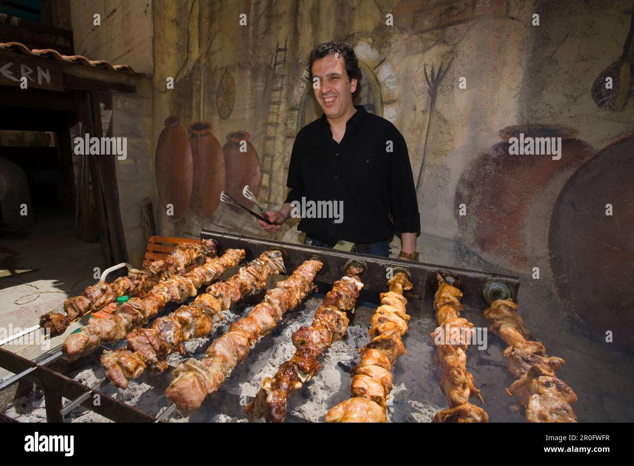 Agis Jacovides, managing director, at a charcoal grill full of quails, The Village Tavern, Pano Platres, South Cyprus, Cyprus Stock Photo
