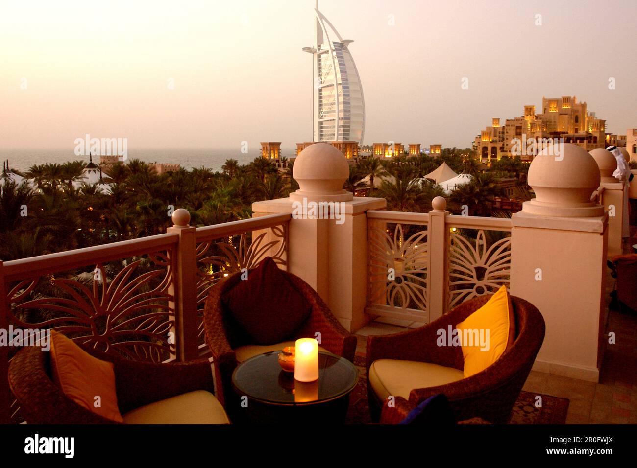 Outdoor Seating at restaurant terrace at dusk, Al Qasr hotel, View at Burj Al Arab Hotel, Madinat Jumeirah, Dubai, United Arab Emirates, UAE Stock Photo