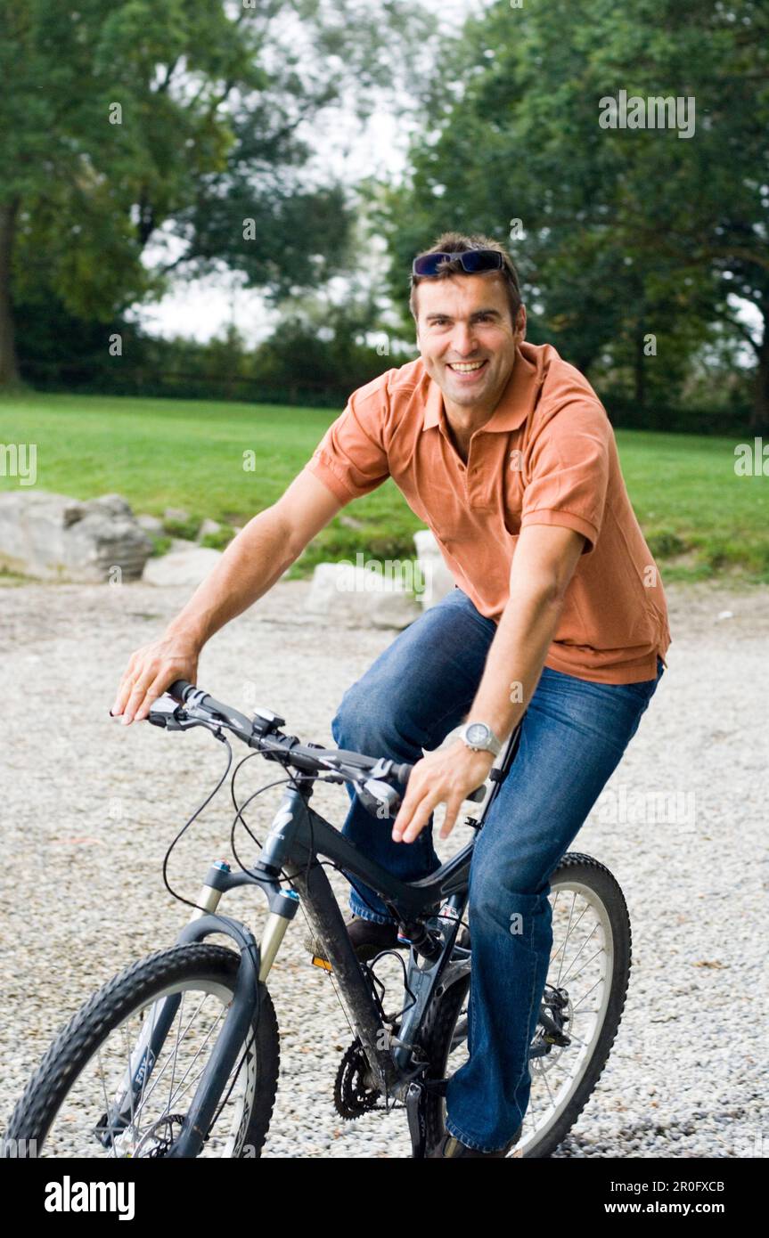 Over Bike Riding Middle aged man riding a bicycle over grass, Bavaria, Germany Stock ...