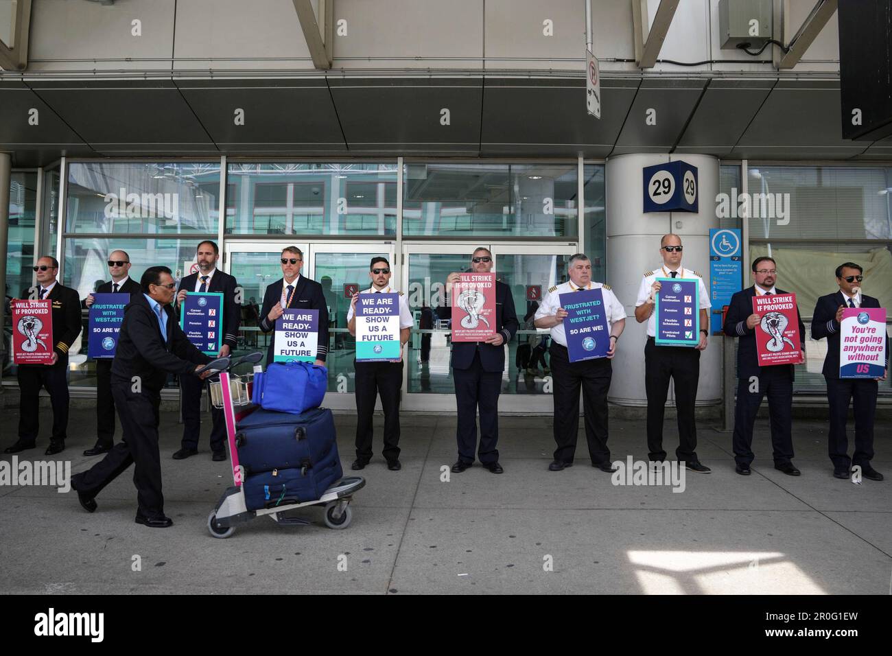 WestJet Airlines pilots stand on a picket line at Toronto's Pearson