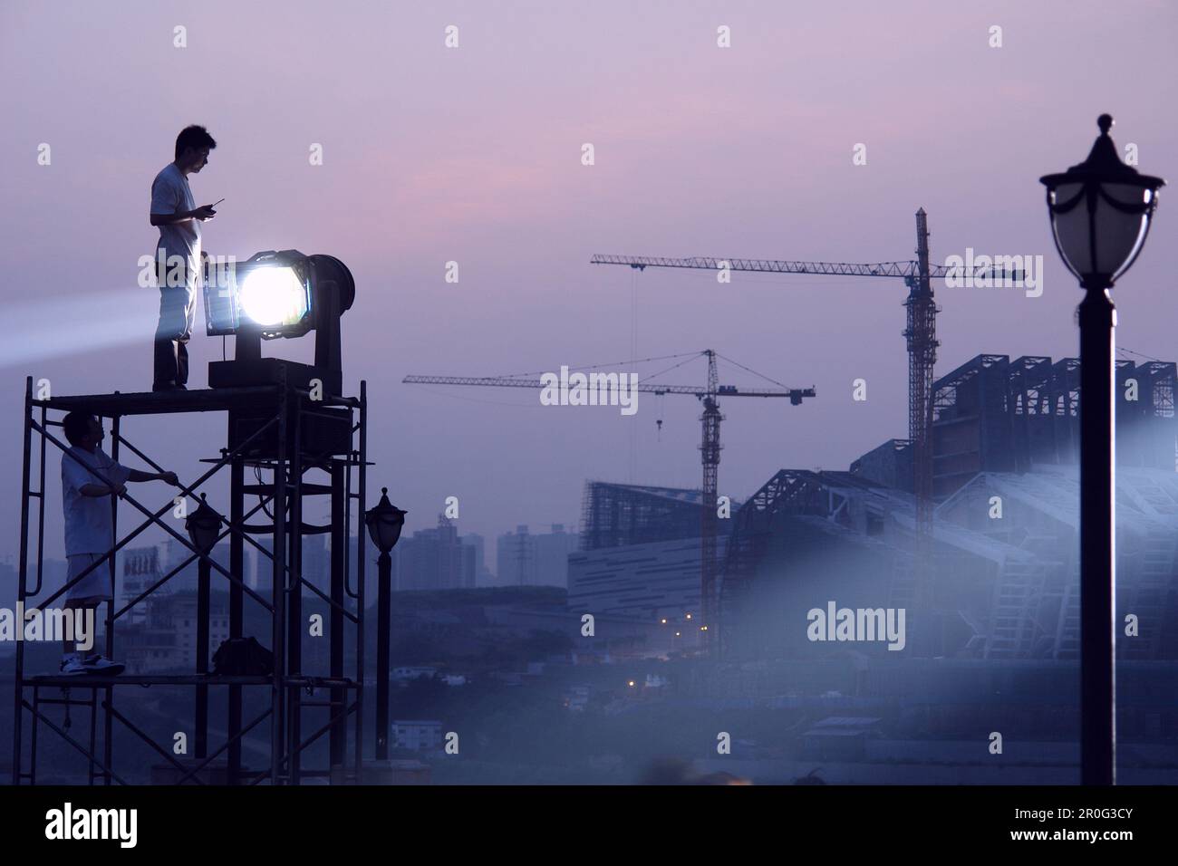 Two illuminators in the attitude of a floodlight on a scaffolding, Chongqing, China, Asia Stock Photo
