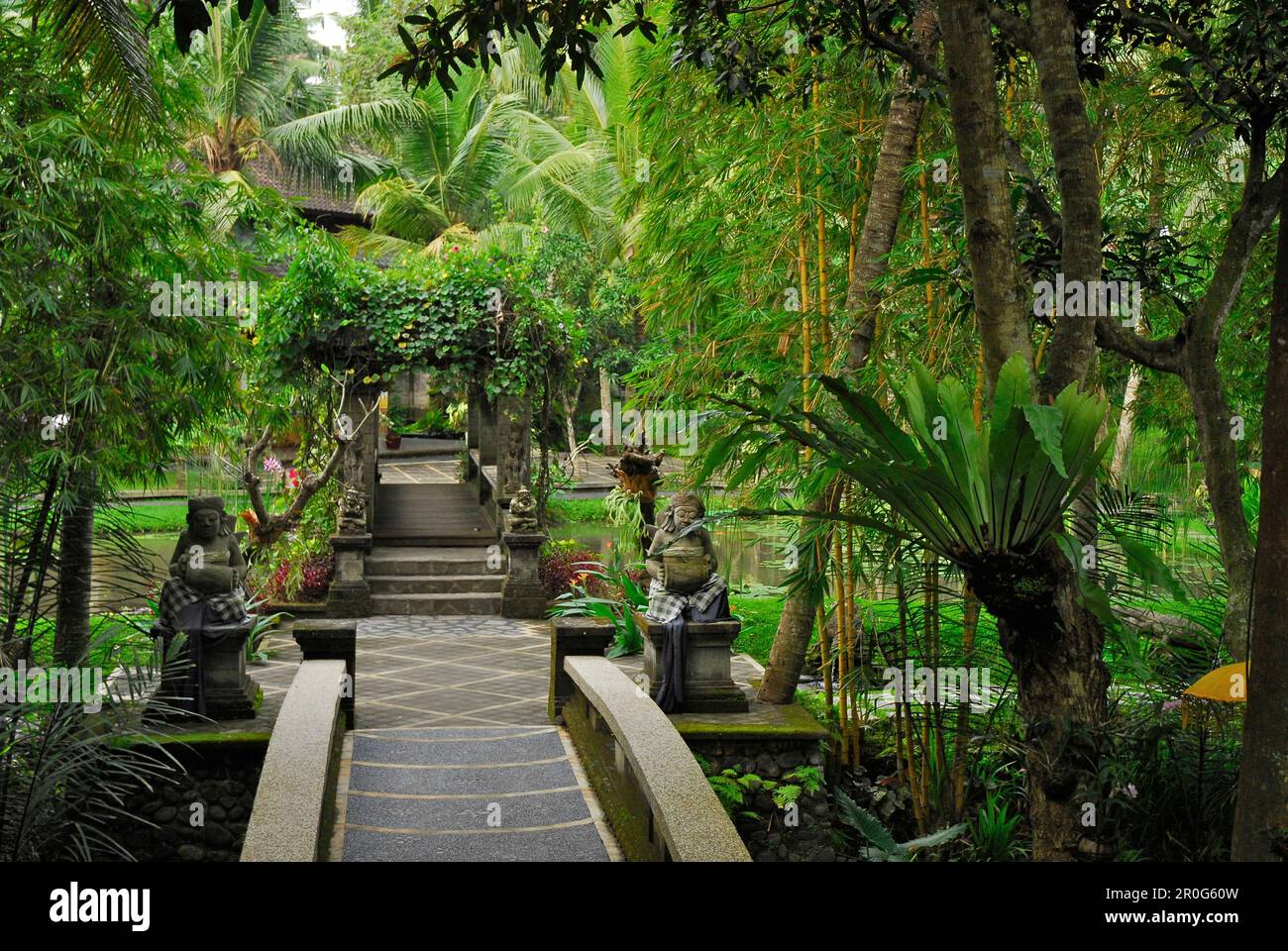 Palm trees and stone figures at the garden of the ARMA museum, Ubud, Bali, Indonesia, Asia Stock Photo