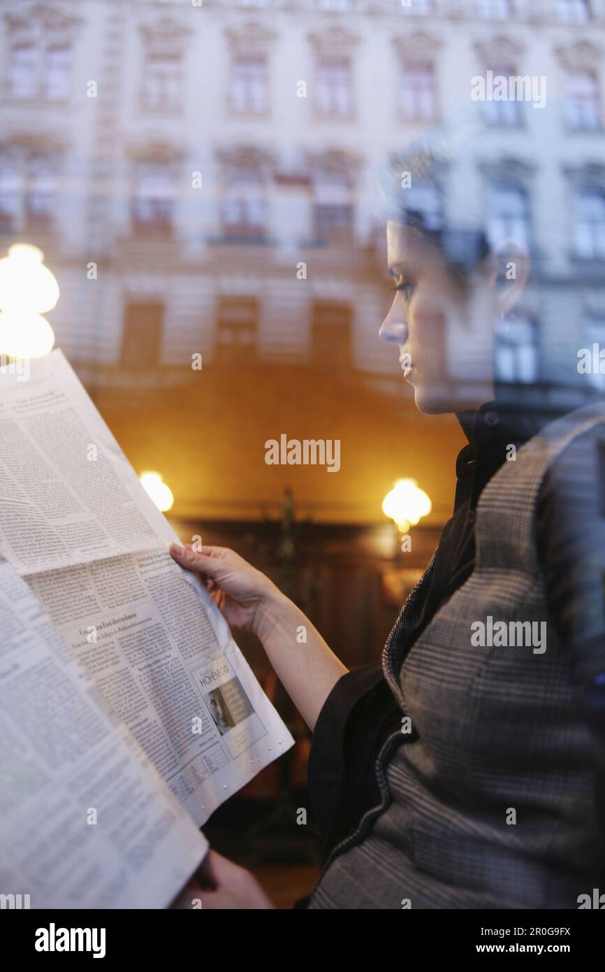 Mid adult woman reading a newspaper in a cafe, Vienna, Austria Stock