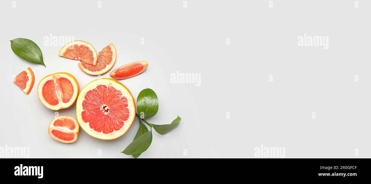 Ripe cut grapefruits on light background with space for text Stock Photo