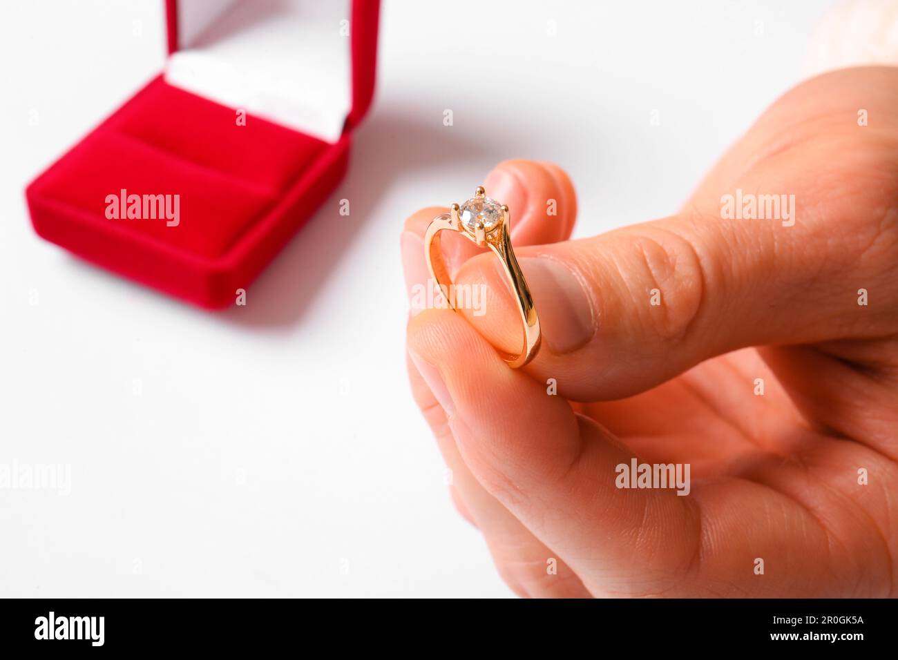 Man with engagement ring and box on white background, closeup Stock