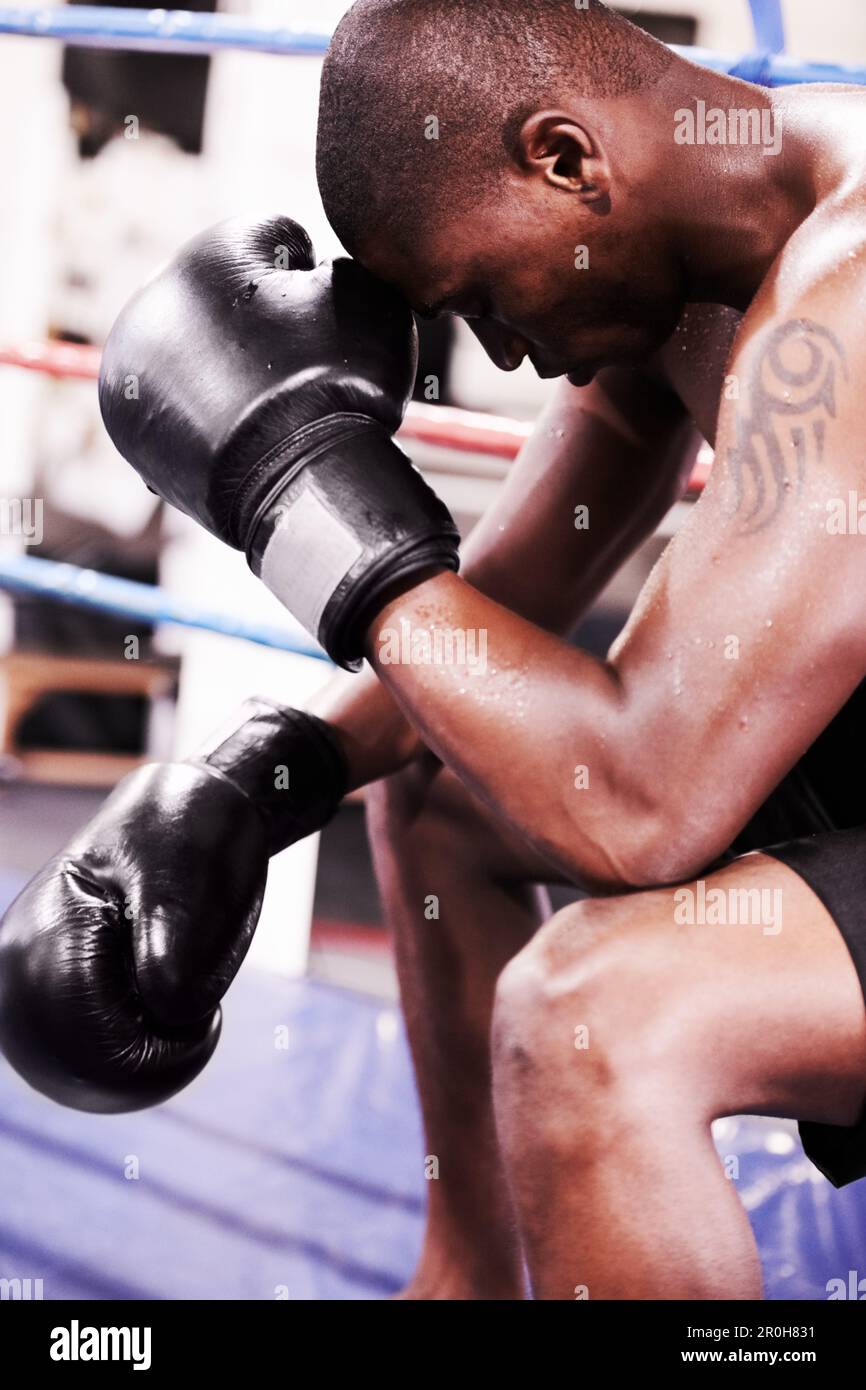 Defeat is only temporary. A boxer taking a moment after losing a fight