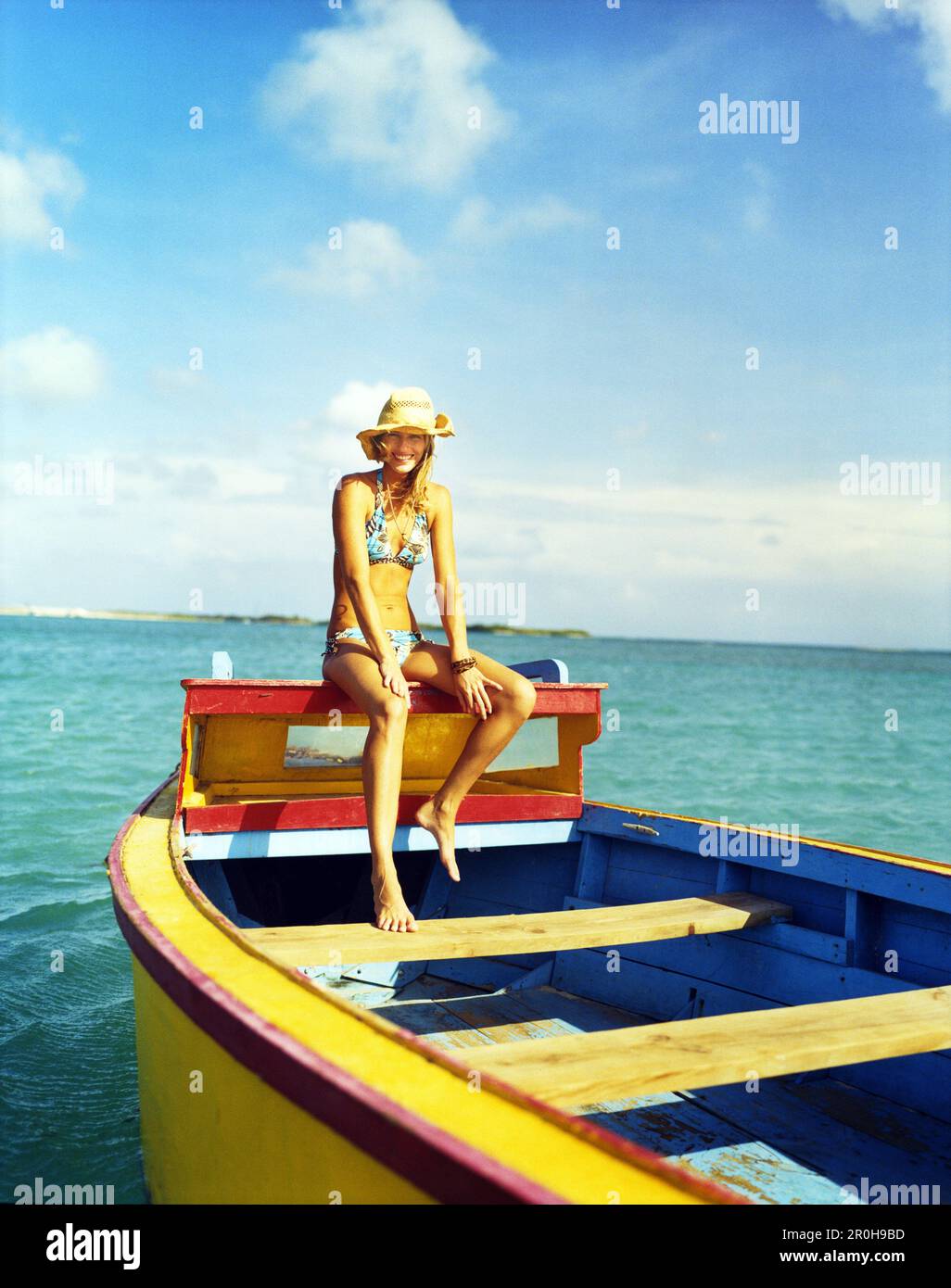 ARUBA, young woman in bikini relaxing on fishing boat, Surfside Beach, Oranjestad Stock Photo