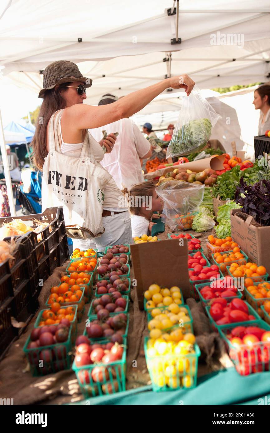 USA, California, Malibu, a woman buys produce at the Malibu farmers