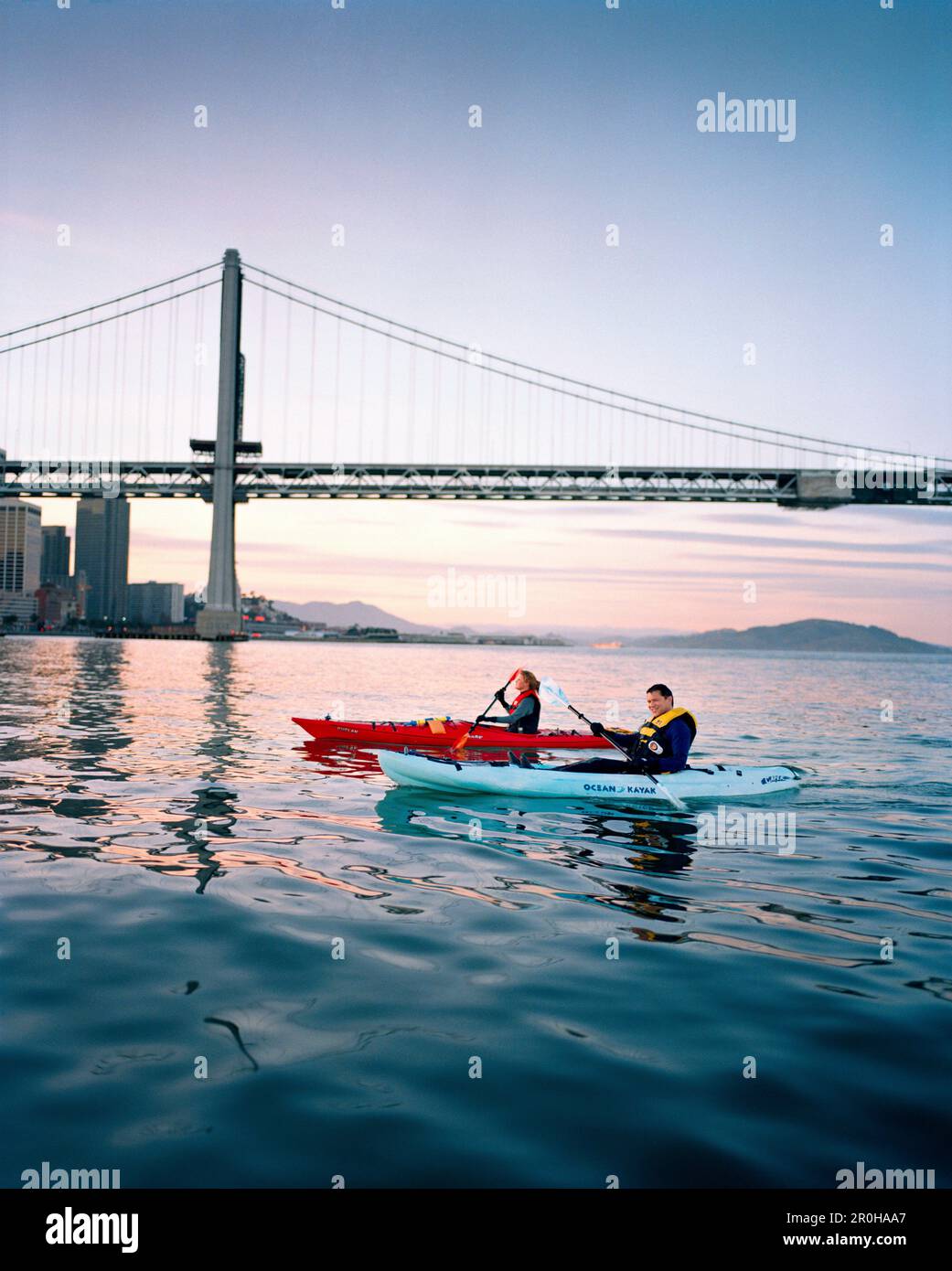 USA, California, San Francisco, a man and woman kayak in the San Francisco Bay under the Bay Bridge, the city of San Francisco in the distance Stock Photo