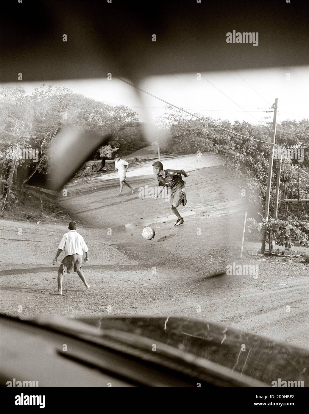 HONDURAS, Roatan, young teenagers playing soccer game (B&W) Stock Photo