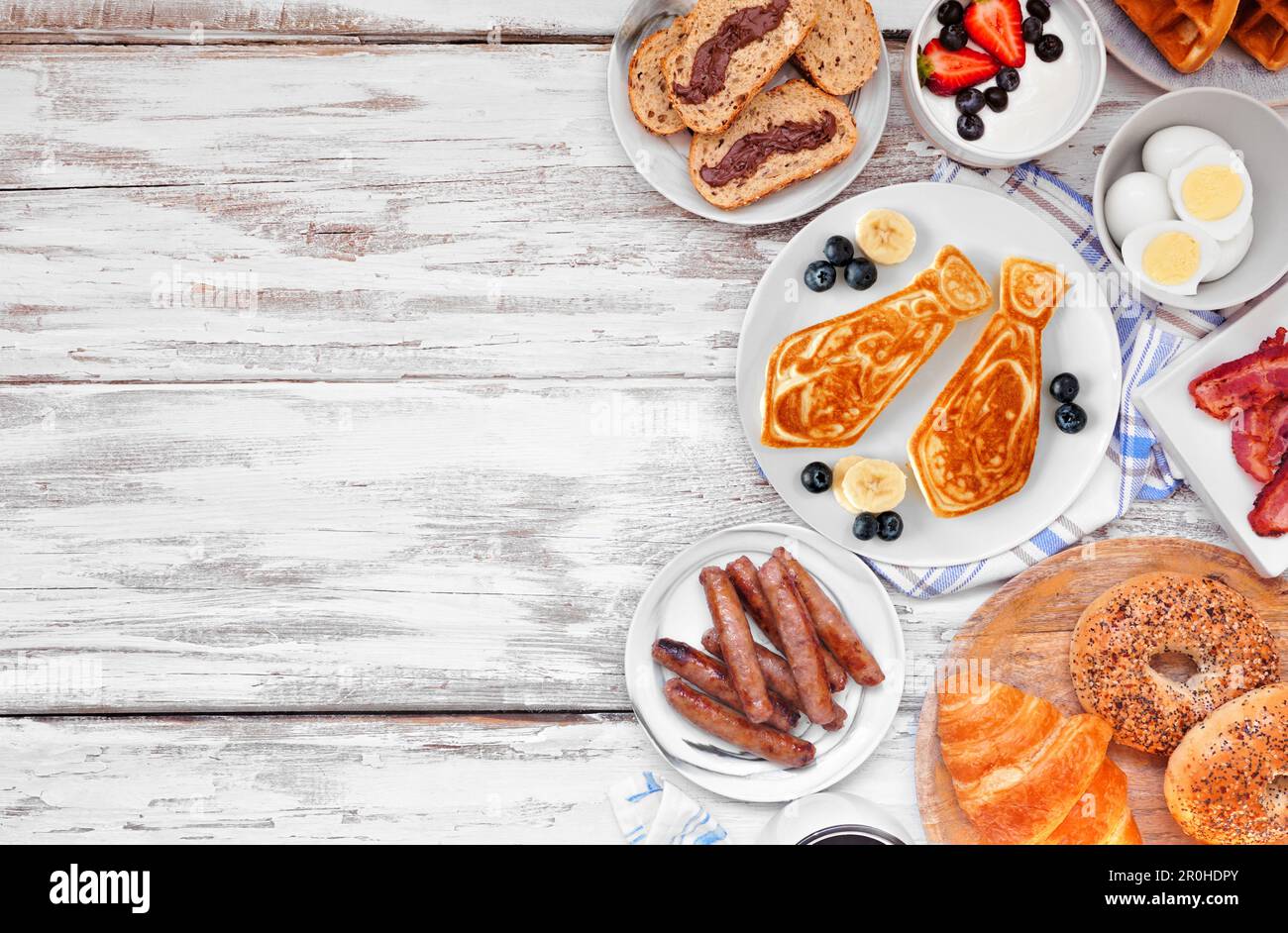 Fathers Day brunch side border. Top view on a white wood background. Tie pancakes, mustache toast and a variety of dad themed food. Stock Photo