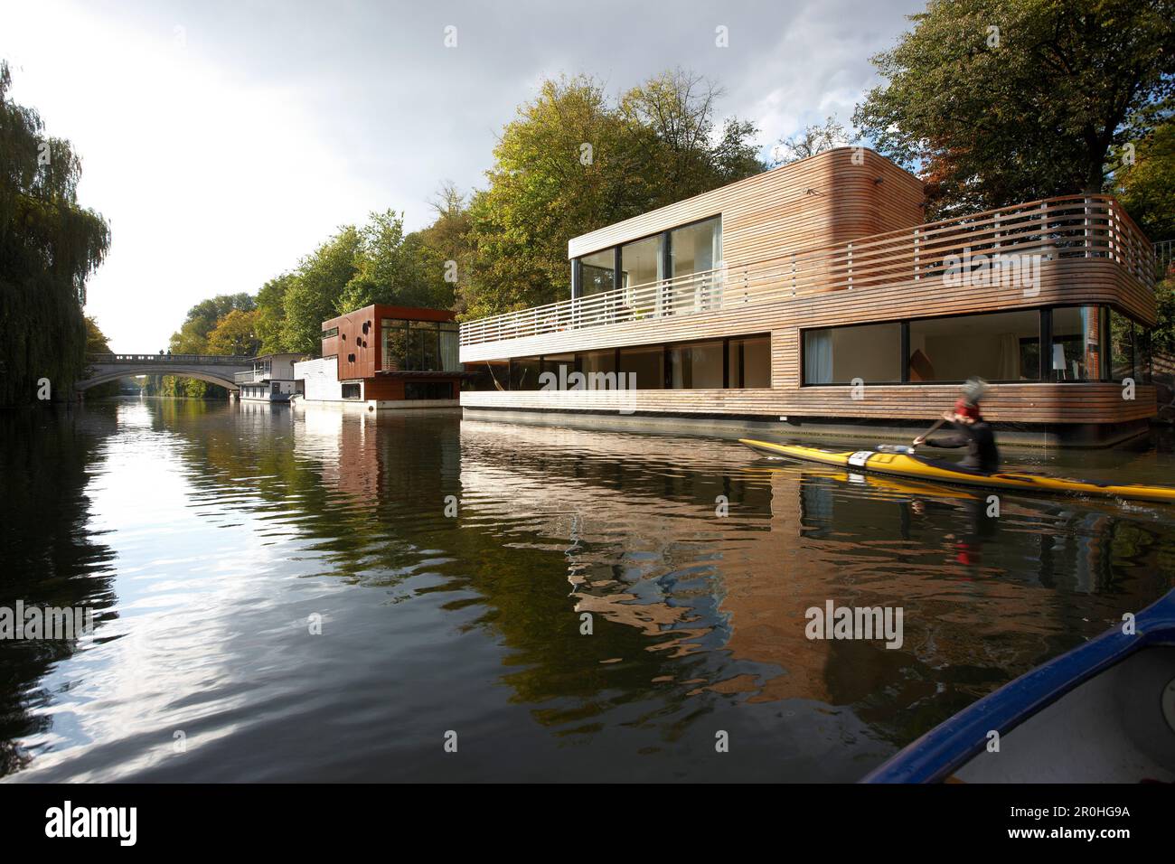Canoe on Eilbek canal passing a houseboat, Hamburg, Germany Stock Photo