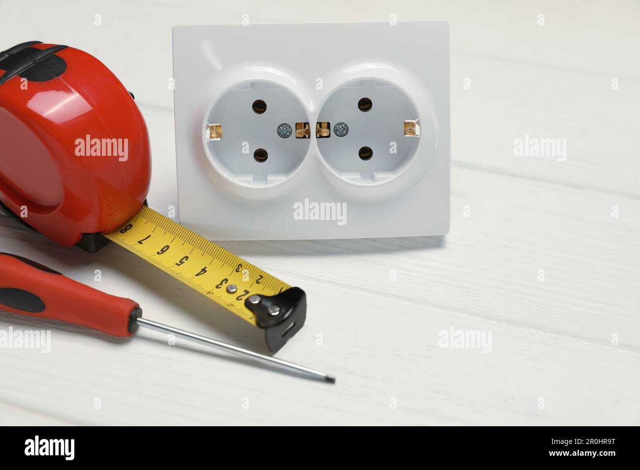Power socket and set of electrician's tools on white wooden table, closeup Stock Photo