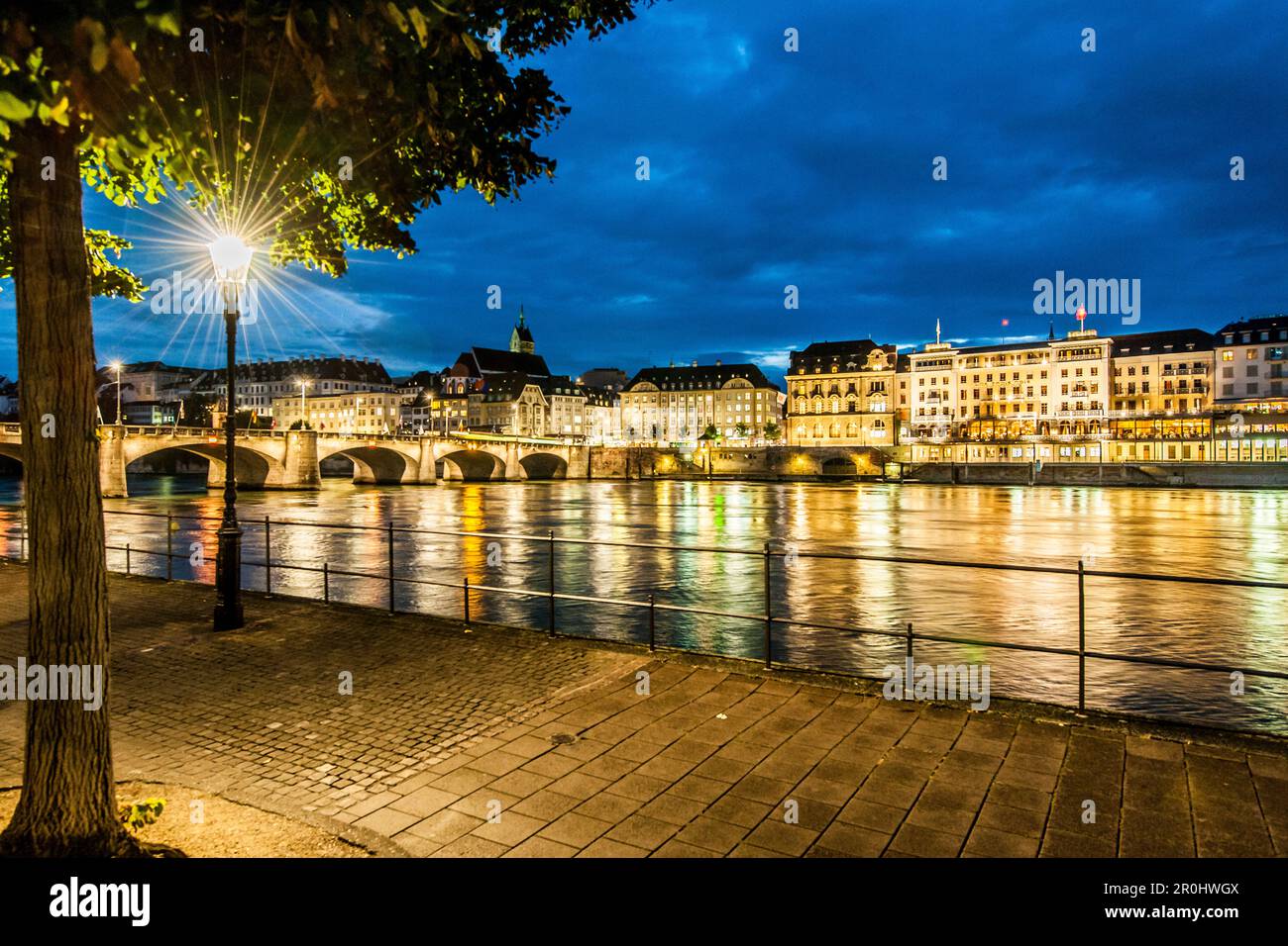 View over the river Rhine with Mittlere Bruecke (Middle Bridge) to a hotel in the evening, Basel, Canton of Basel-Stadt, Switzerland Stock Photo