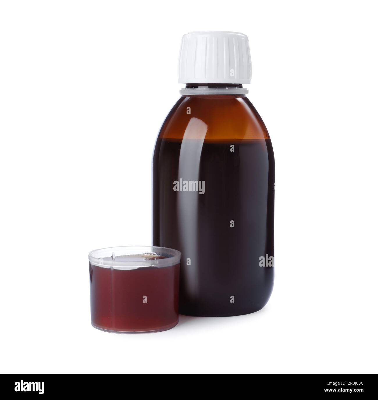 Bottle with measuring cup of syrup on white background. Cough and cold