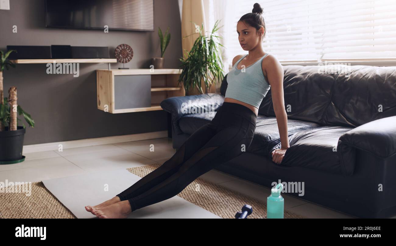 I love the burn in my arms. a young woman performing tricep dips at home as part of her workout
