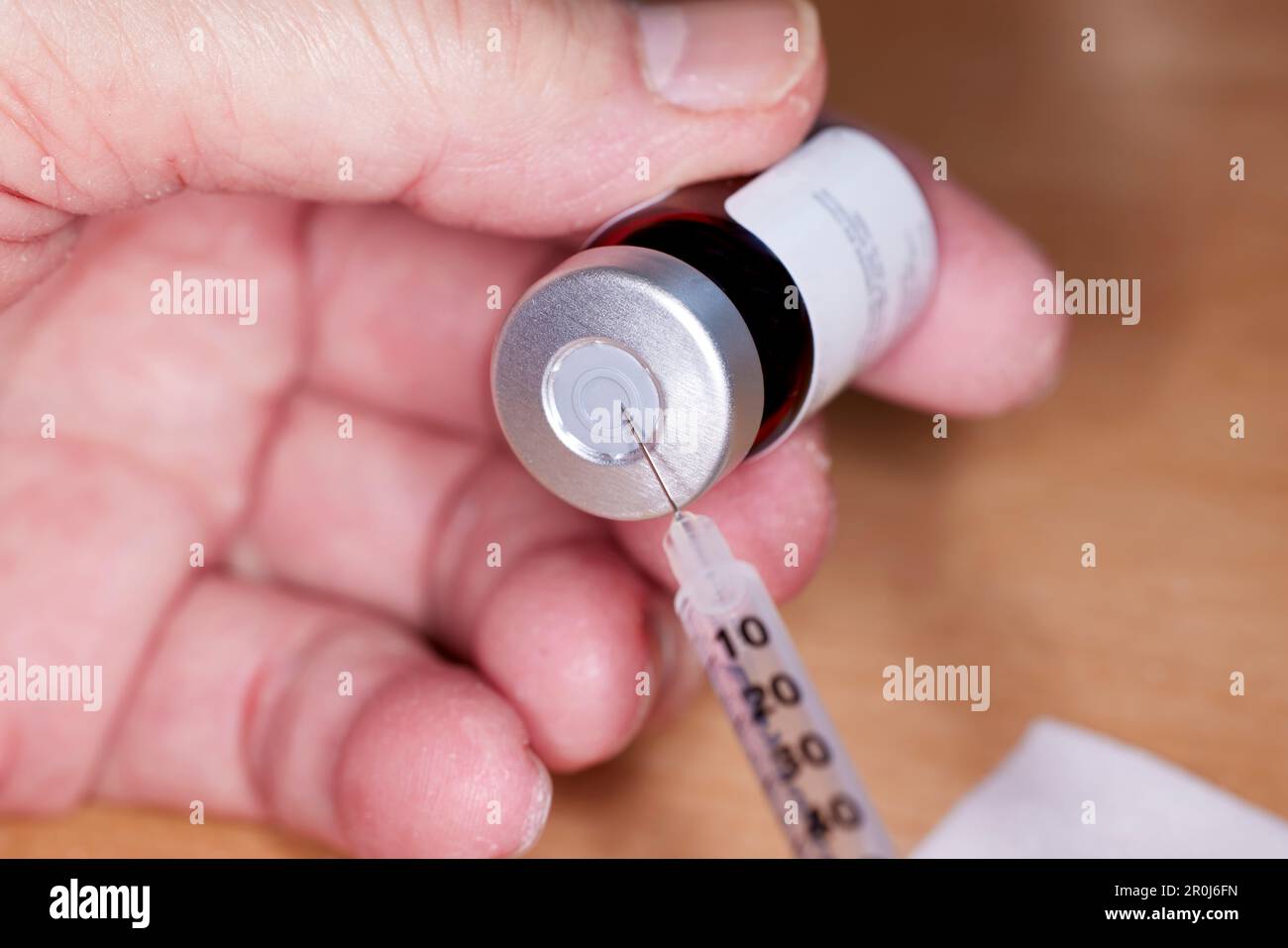 Close up of handheld needle and syringe with Testosterone Vial Stock