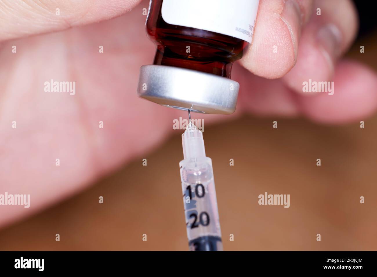 Close up of handheld   needle and syringe with Testosterone Vial Stock Photo