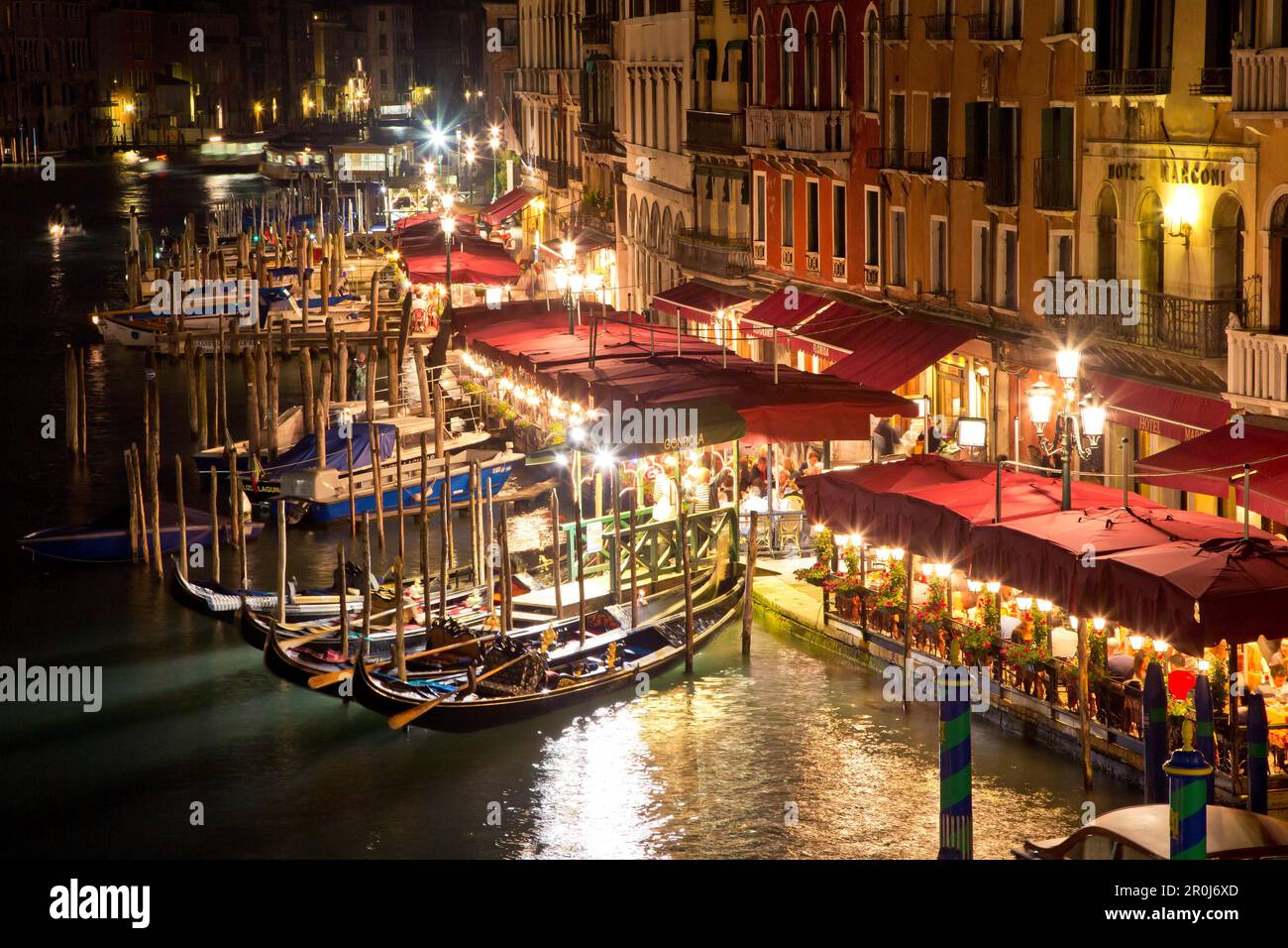 View from Rialto bridge to gondolas and restaurants along the Grand Canal at night, Venice, Veneto, Italy, Europe Stock Photo