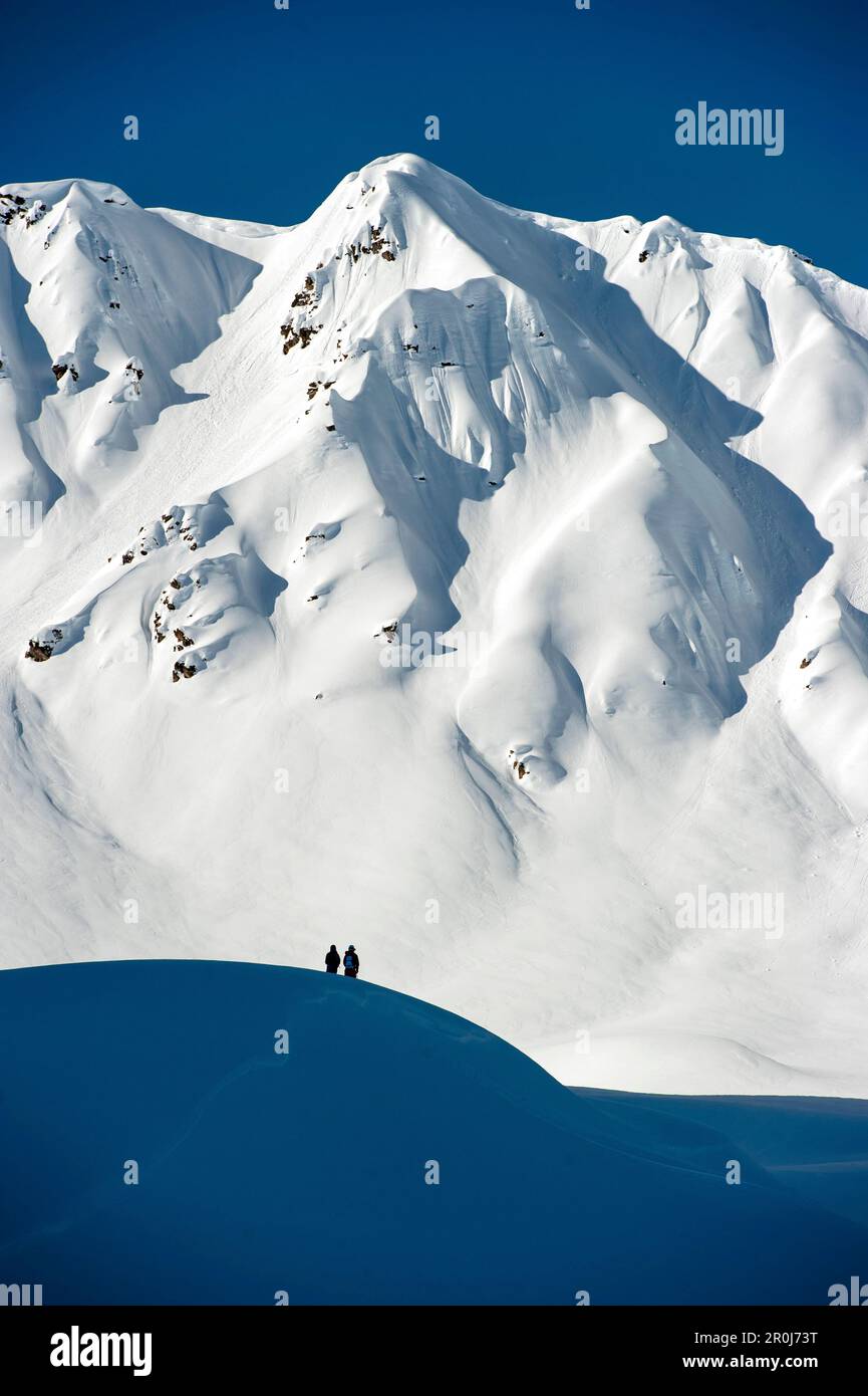 Two persons in snow-covered mountain scenery, Gargellen, Montafon, Vorarlberg, Austria Stock Photo