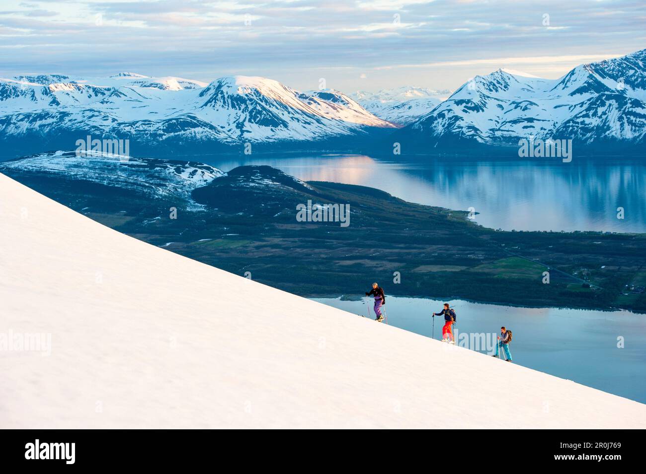 Skiers ascending in midnight sun, Lyngen Alps, Troms, Norway Stock Photo
