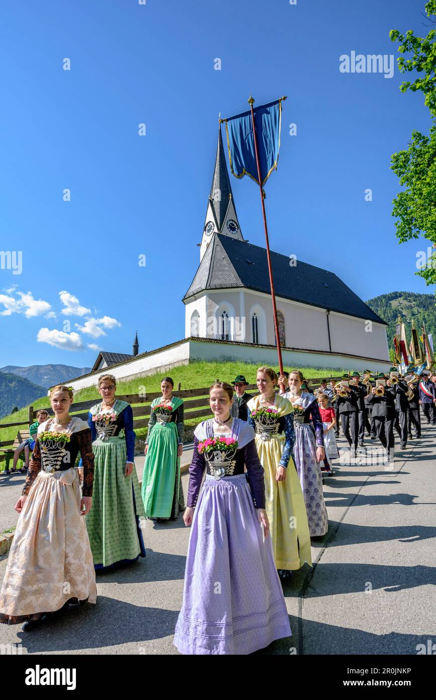 Procession during religious festival of Feast of Corpus Christi, church of Kreuth in background, Kreuth, Bavarian Alps, Upper Bavaria, Bavaria, German Stock Photo