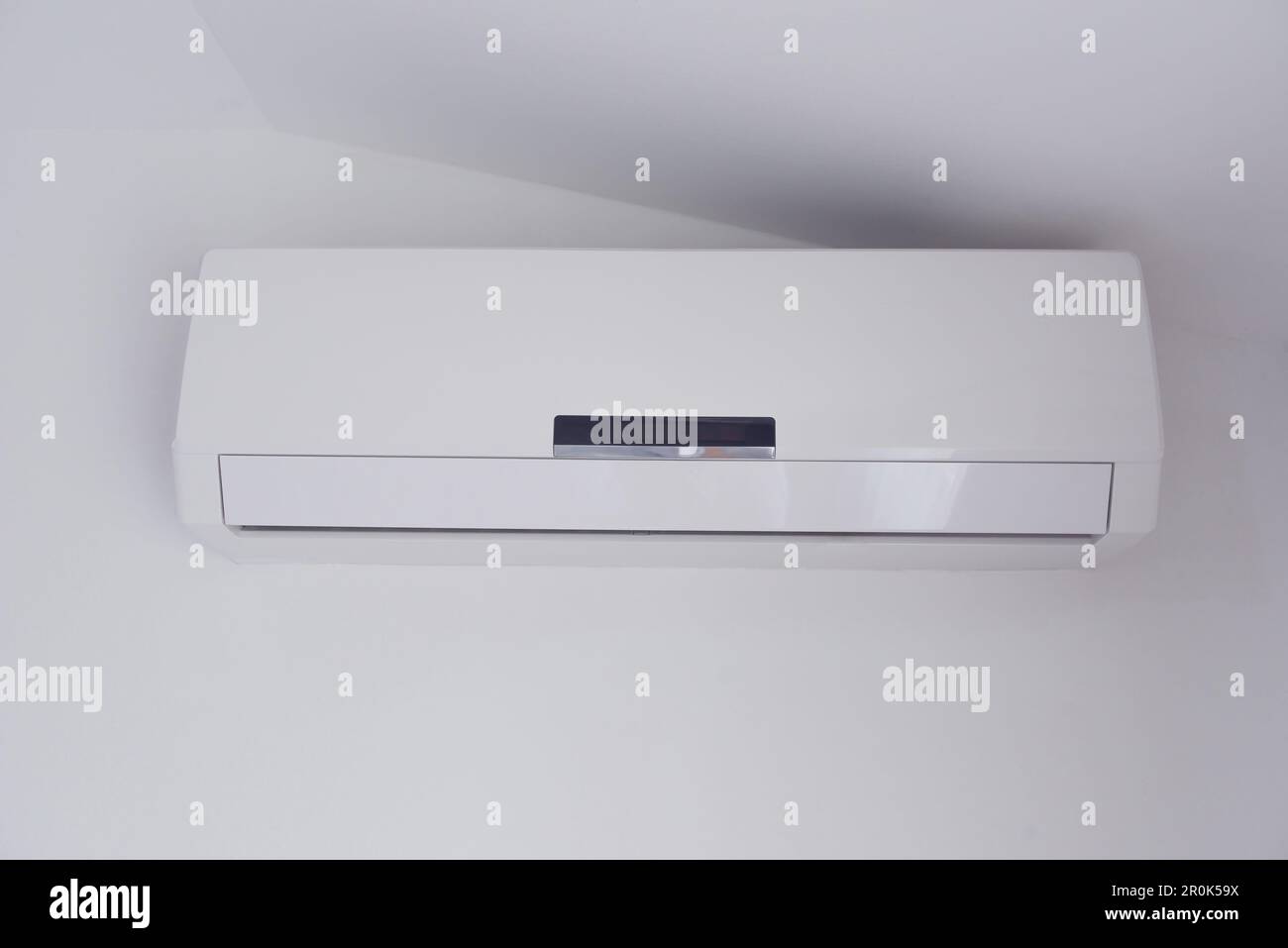 Air conditioner mounted on a white wall of apartment bedroom with copy space Stock Photo