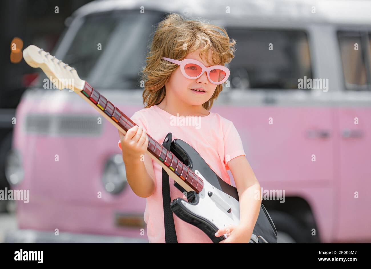 Funny rock kid with guitar. Concept of music hobby Stock Photo Alamy