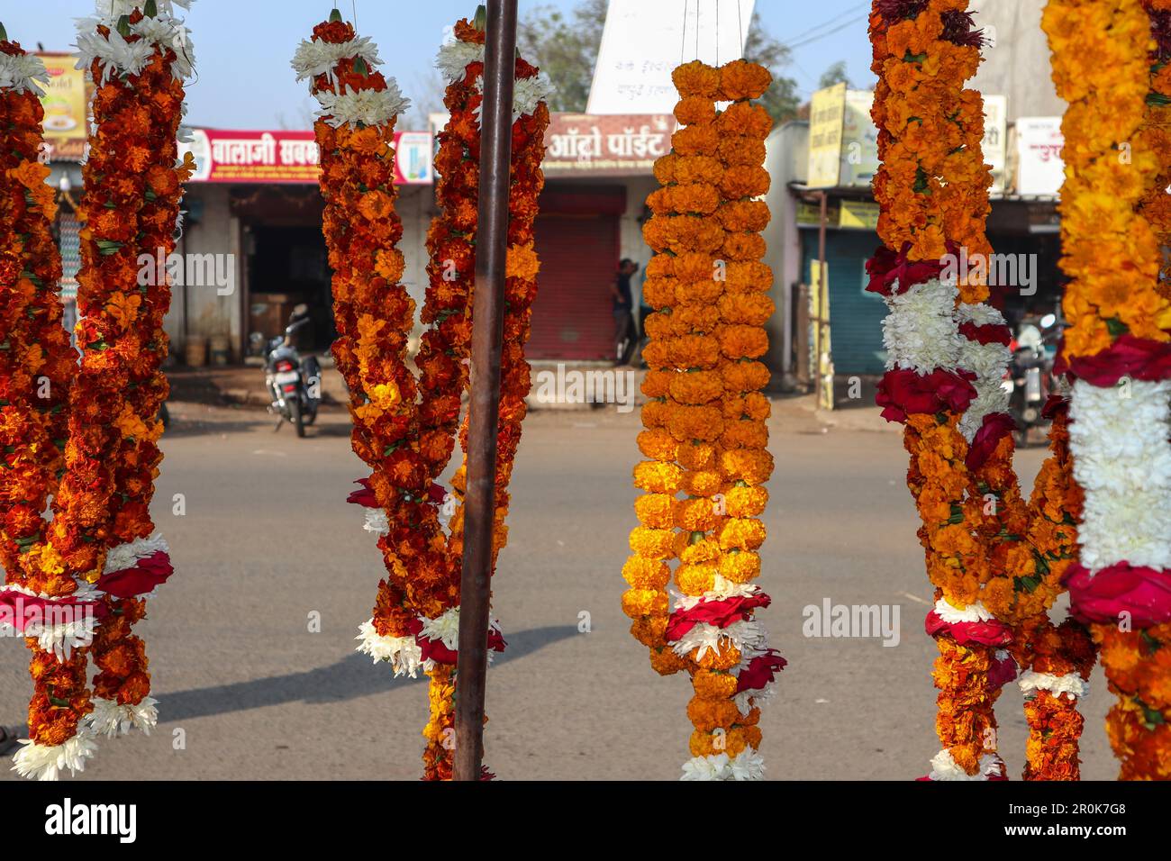 Flower garlands made of Marigold flowers and rose flowers hanging in street stall shop in India