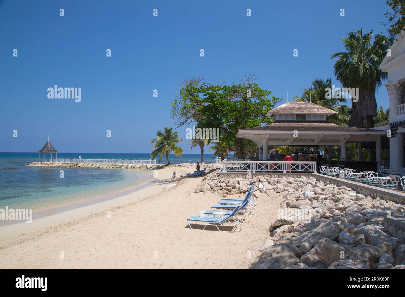 Beach chairs on Sunset Beach, Cedar Bar and jetty with pavillion at