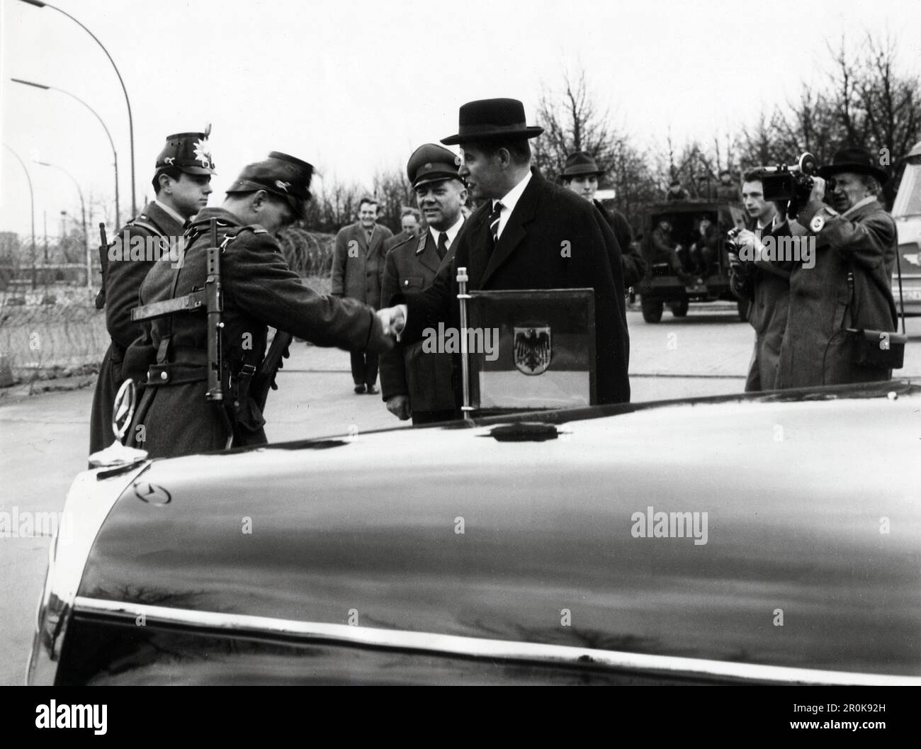 Original-Bildunterschrift: Bundesaußenminister Dr. Schröder informiert sich an Ort und Stelle - Einen Tag, ehe der neue deutsche Aussenminister Dr. Gerhard Schröder mit Bundeskanzler Dr. Adenauer zur Erörterung der schwierigen politischen Lage nach Washington fliegt, besuchte er Berlin, um sich an Ort und Stelle einen unmittelbaren Eindruck der Lage in Berlin schaffen zu können, hier am Brandenburger Tor. Bei seiner Fahrt entlang der Schandmauer wurde er vom persönlichen Referenten des derzeit erkrankten Regierenden Bürgermeisters von Berlin, Schulz, und dem Kommandant der Berliner Schutzpoliz Stock Photo