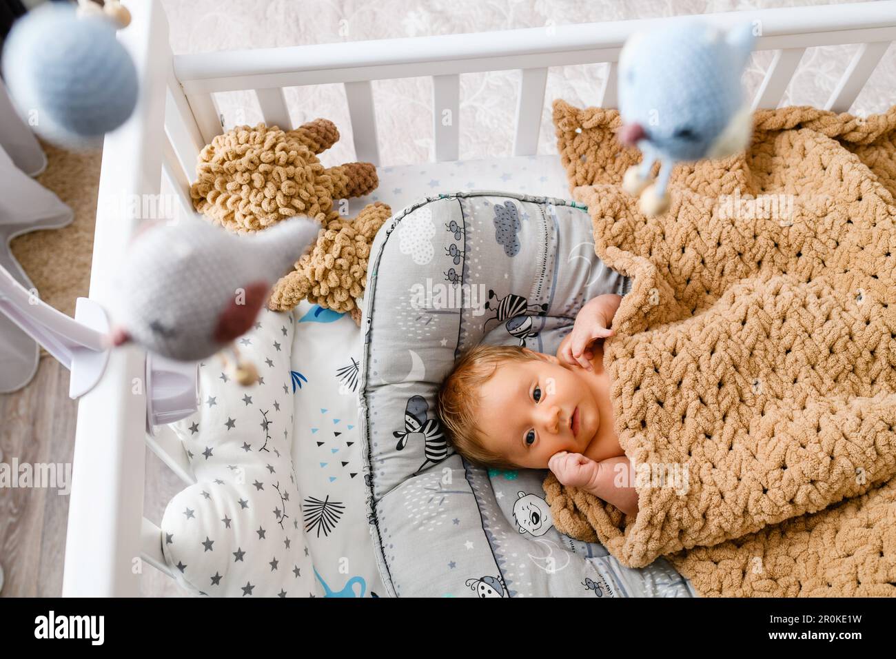 Top view of cute infant baby laying on his back in a wooden cot Stock Photo Alamy