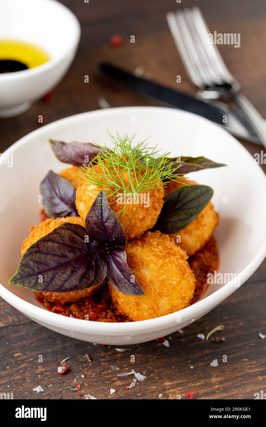 Homemade Fried Sicilian Arancini stuffed with meat, with tomato sauce Stock Photo