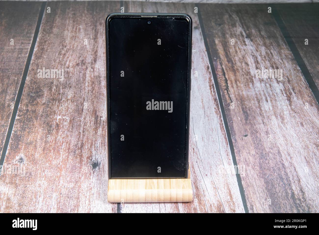 Mobile phone with dark empty Handydisplay for text free space on wooden