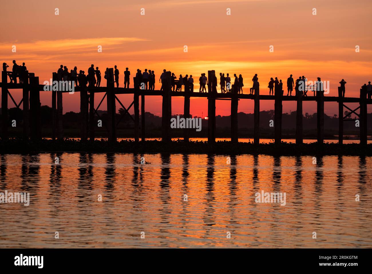 Silhouette of people walking along U Bein Bridge across Taungthaman ...