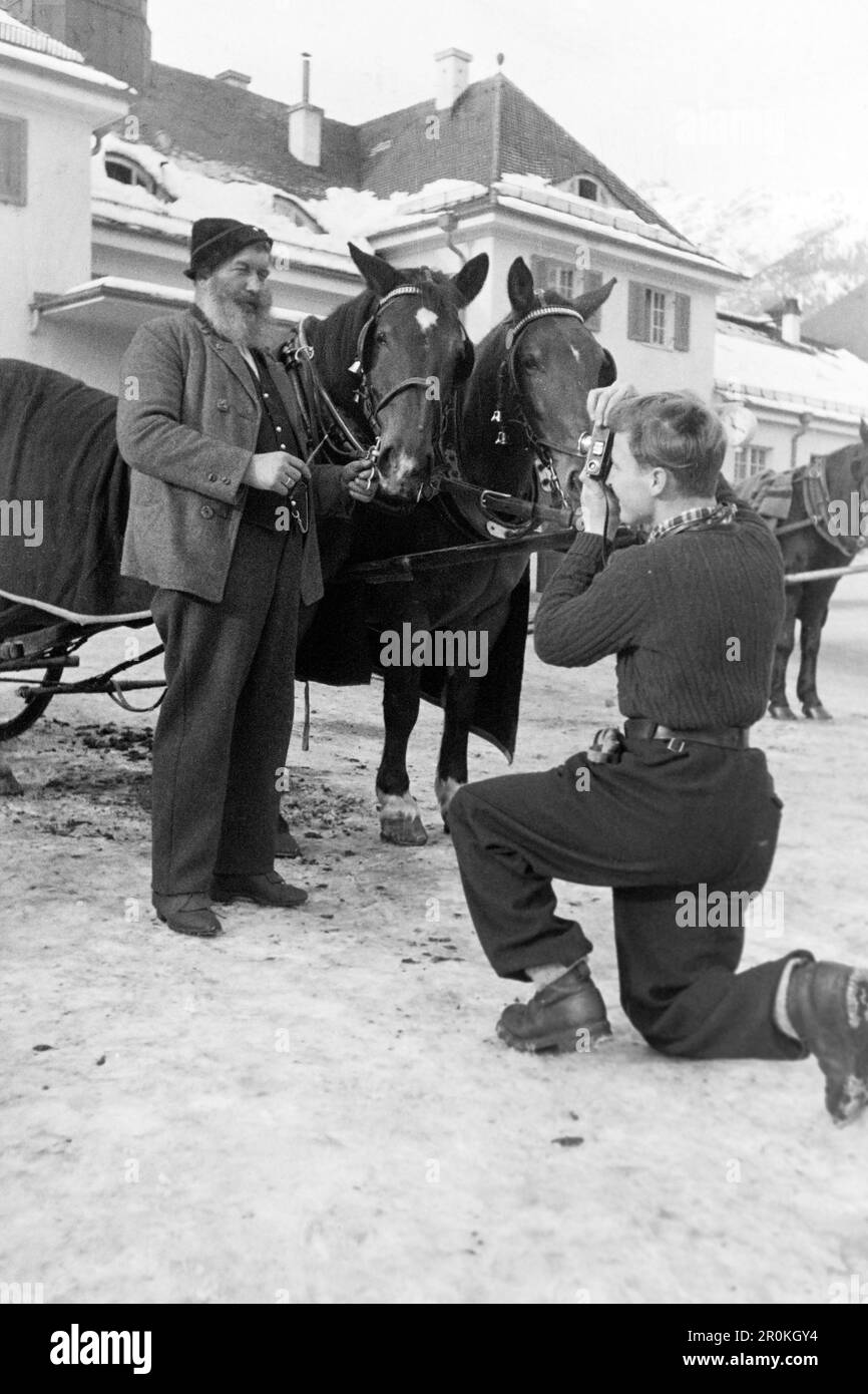 Tourist fotografiert einen Kutscher mit seinen Pferden, Garmisch