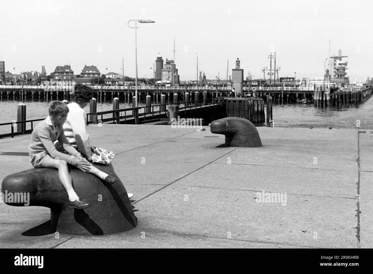 Frau und Junge blicken vom Steubenhöft auf den Alten Hafen mit Leuchtturm, Semafor, Radarturm und der Alten Liebe, Cuxhaven, 1960. Woman and boy looking from Steubenhöft at the Old Harbour with lighthouse, Semafor, radar tower and the Old Love, Cuxhaven, 1960. Stock Photo