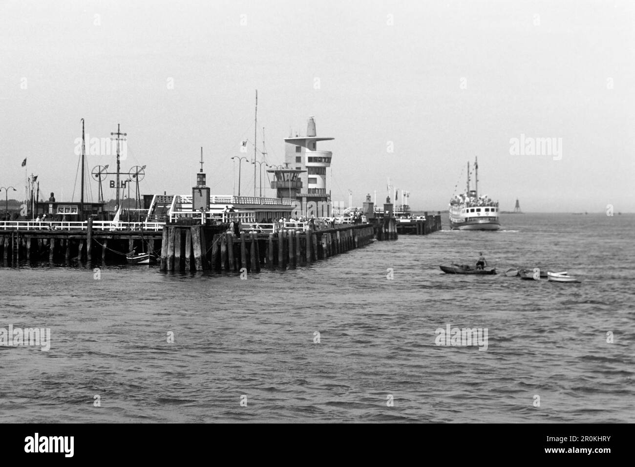 Blick auf die Alte Liebe in Cuxhaven, links der Semafor, in der Mitte der Radarturm und rechts neben dem Passagierschiff das Wahrzeichen Cuxhavens, die Kugelbake, 1960. View of the Alte Liebe in Cuxhaven, the Semafor on the left, the radar tower in the middle and Cuxhaven's landmark, the Kugelbake, to the right of the passenger ship, 1960. Stock Photo