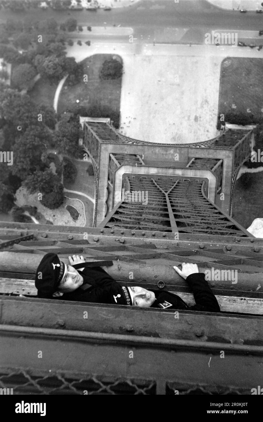 Zwei Soldaten der deutschen Kriegsmarine auf der Nordost-Seite des Eiffelturms, Paris 1940. Two German Kriegsmarine soldiers on the north-east side of the Eiffel Tower, Paris 1940. Stock Photo