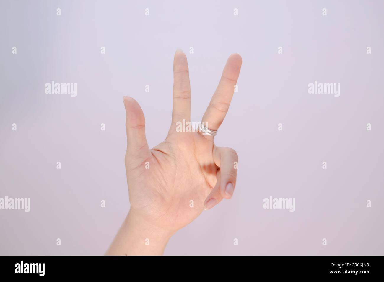 closeup woman hand showing three fingers sign language isolated on